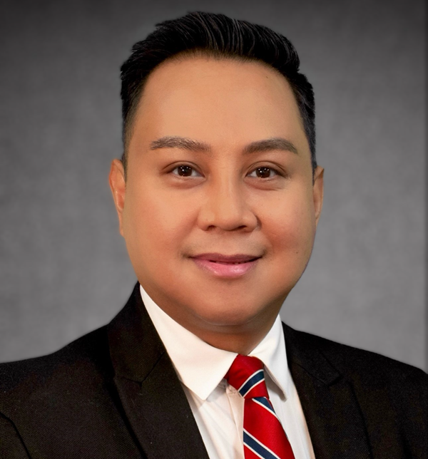 Portrait of Rey Resario, wearing a suit and tie