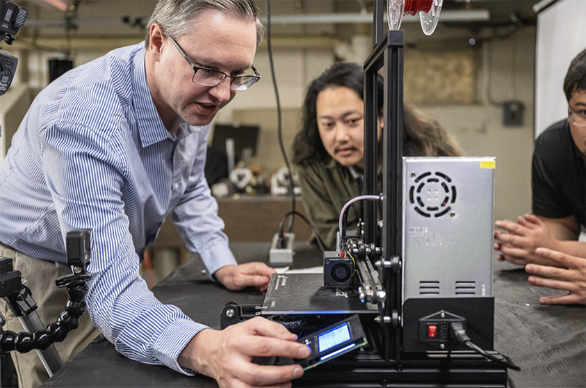 Photograph of Professor Tom Madura and students in a classroom laboratory.