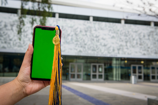 a cell phone held up against a campus scene